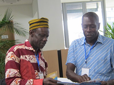 A. Sall zeigt dem Vertreter der nationalen Fischereiorganisation in Gambia die Unterrichtshilfen